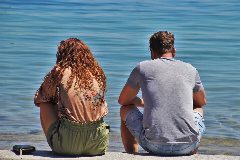 Frau und Mann sitzen am Strand im Streit