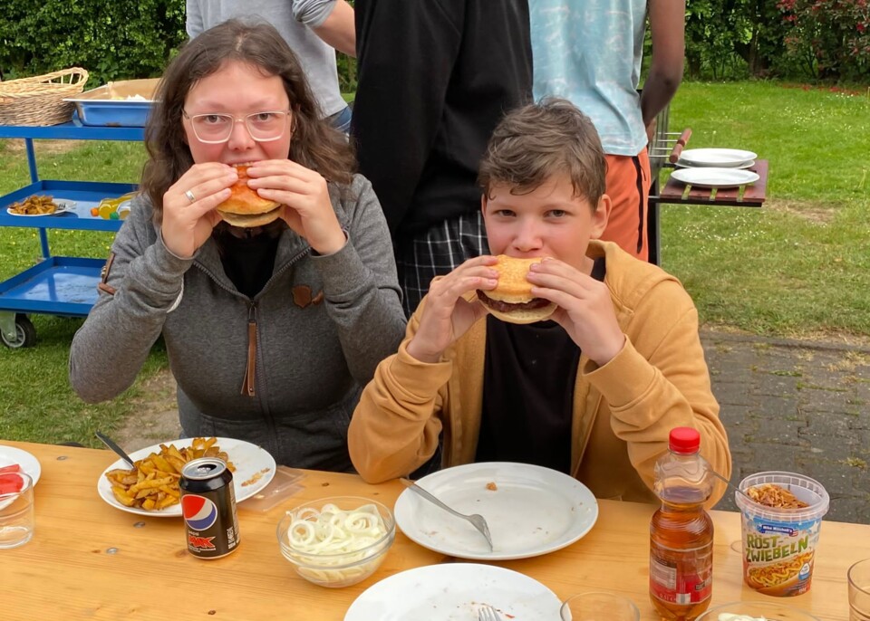 Schnappschuss von Anna Lena und Niklas, die in einen Burger beißen, Foto von Anna Lena