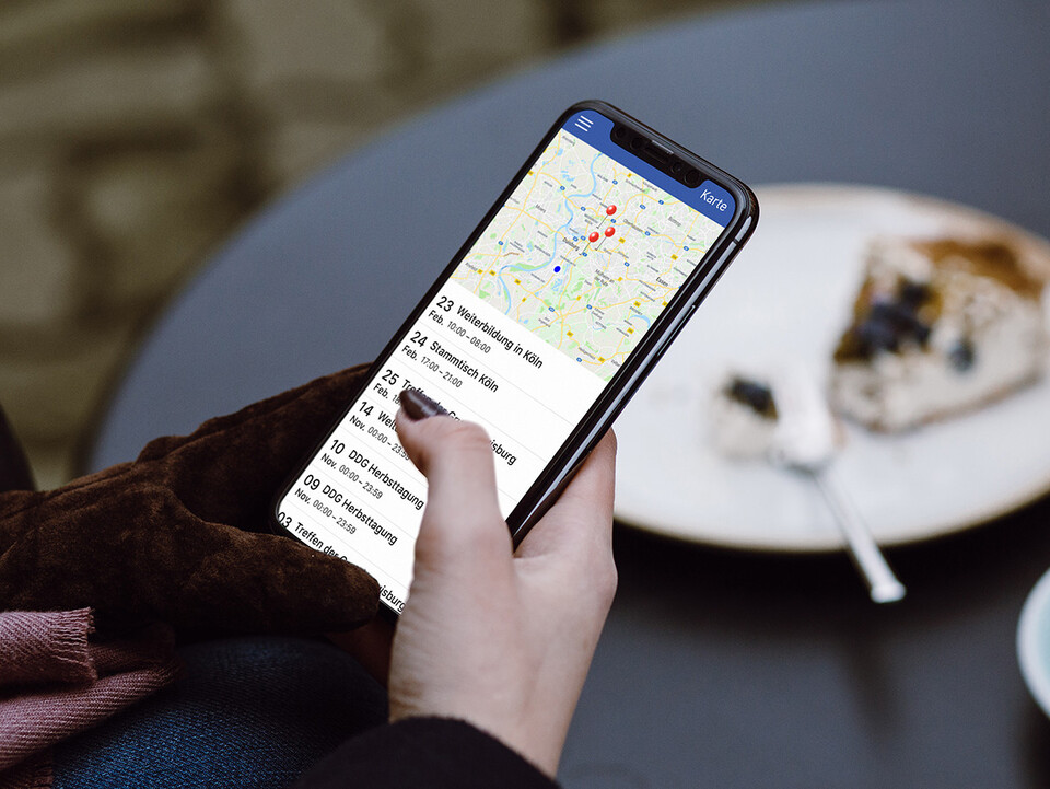 Smartphonenutzerin mit der App DDH-M Digital auf dem Bildschirm.